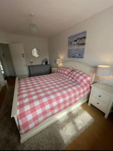 波特巴林崔的住宿－Holiday Home- Portballintrae，一间卧室配有一张带红白色拼盘的床铺。