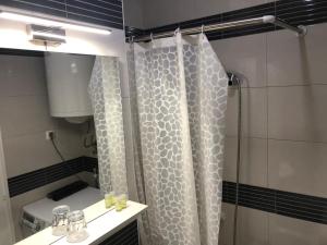 uma casa de banho com uma cortina de chuveiro e um lavatório em AnDi em Osijek
