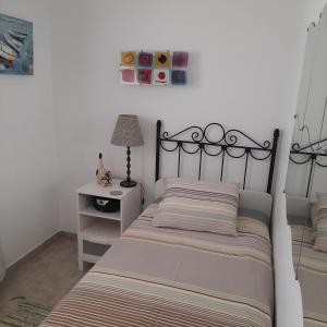 a bedroom with a bed and a table with a lamp at Villa julima in Playa Blanca