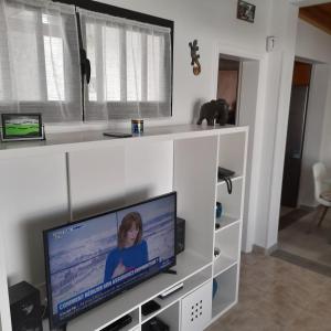 uma sala de estar com uma televisão de ecrã plano numa prateleira branca em Villa julima em Playa Blanca