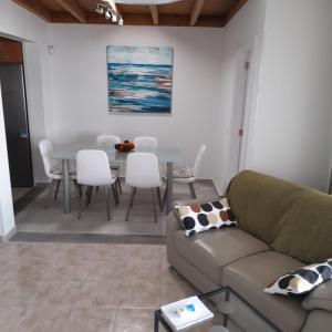 een woonkamer met een bank en een tafel en stoelen bij Villa julima in Playa Blanca