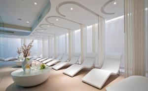 a room with a row of white chairs and tables at Porto Platanias Beach Resort & Spa in Plataniás