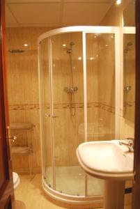 una ducha con una puerta de cristal junto a un lavabo en Apartamento Antón Gómez, en Lucena