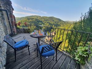 uma mesa e cadeiras num deque de madeira com vista em Chambre d'Hôtes au Château de Belcastel em Belcastel