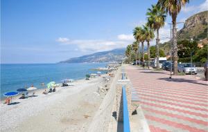 una playa con palmeras y gente en la playa en Amazing Apartment In Cetraro With Kitchen, en Cetraro