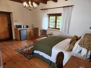 um quarto com uma cama, uma mesa e um micro-ondas em Yellowwood House em Tulbagh