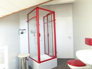 baño con ducha con marco rojo en Göttliche Vogelstimmen Gäste aus 57 Nationen en Bad Boll