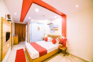une chambre d'hôtel avec un lit au plafond orange dans l'établissement Hotel Grandeur-Near Mumbai International Airport, à Mumbai