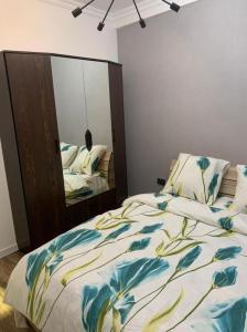 een slaapkamer met een bed en een grote spiegel bij студия Вефа in Bisjkek
