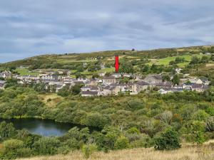 eine kleine Stadt auf einem Hügel mit einer roten Flagge in der Unterkunft North Wales Cosy Cottage with views near Eryri Snowdonia in Nantlle