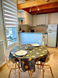 a kitchen with a table with chairs and a kitchen with a refrigerator at Maison de Ville Lumineuse centre ville à pieds - Lit 160 in Quimper