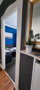 ein Zimmer mit einem Spiegel und einem Tisch mit einer Pflanze in der Unterkunft Goldhand Chill Point Bielefeld in Bielefeld