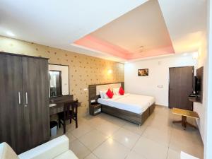 a bedroom with a bed and a sink and a desk at Victory Grand Attibele in Bangalore