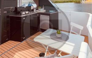 a table and chair on the deck of a boat at Cozy Ship In Havelsee With Kitchen in Milow