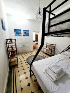 sypialnia z łóżkiem piętrowym i podłogą wyłożoną kafelkami w obiekcie P Casa con Azotea privada y Céntrica. WiFi+Netflix w mieście El Puerto de Santa María