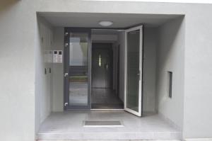 un couloir vide avec des portes en verre dans un bâtiment dans l'établissement Severan New Appartement 1, à Martin
