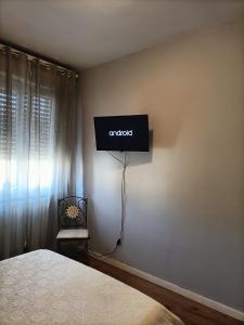 a bedroom with a bed and a television on the wall at Franciacorta flat & bollicine in Passirano
