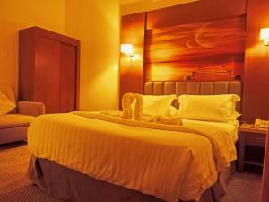 a bedroom with a large bed with a wooden headboard at Taraf Yanbu 2 in Yanbu