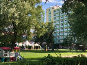 a park in front of a large building at Hotel Magistern Konferencia és WellnessHotel in Siófok