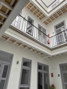 un gran edificio blanco con balcón y puertas en Apartamentos Casa Macías, en Cádiz