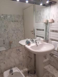 a white bathroom with a sink and a toilet at Vue mer aux portes de Monaco in Beausoleil