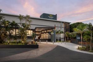 a building with palm trees in front of it at Premier Resort Cutty Sark in Scottburgh