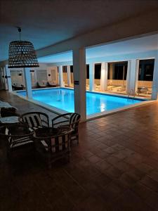 a large swimming pool with chairs and a pendant light at Casa Victoria Suites in Sant Josep de sa Talaia