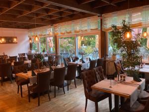 a restaurant with wooden tables and chairs and windows at Haus Sommerhof in Sindelfingen