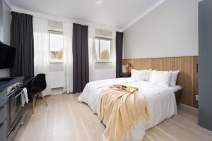 um quarto de hotel com uma cama grande e uma televisão em Foundry Hotel Apartments em Uppsala