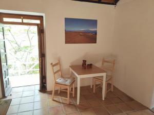 a dining room with a table and chairs and a window at Casa Panama in Hermigua