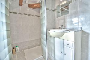 y baño blanco con lavabo y bañera. en Superbe appartement centre-ville, en Nogent-le-Roi