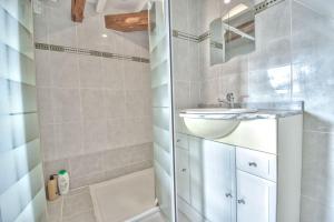 a white bathroom with a sink and a bath tub at Superbe appartement centre-ville in Nogent-le-Roi