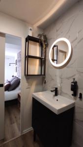 a bathroom with a sink and a mirror and a bed at Nouveau* Vintage Mecanic* Wifi*Netflix*Confort in Venette