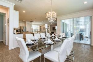a dining room with a table and white chairs at Sonoma Resort 7 Bedroom Vacation Home 2600YA in Kissimmee