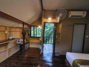 a small room with a bed and a room with a window at Malulee KhaoSok Resort in Khao Sok