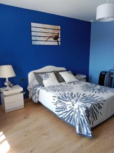 niebieska sypialnia z łóżkiem i niebieską ścianą w obiekcie L OLIVIER DE ST LEGER w mieście Château
