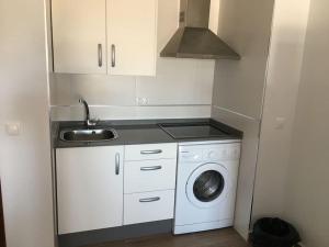 una pequeña cocina con lavadora y fregadero en Moderno apartamento en Bahia Sur, en San Fernando