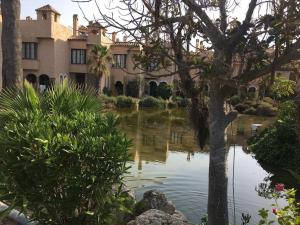 a house with a pond in front of a building at Moderno apartamento en Bahia Sur in San Fernando