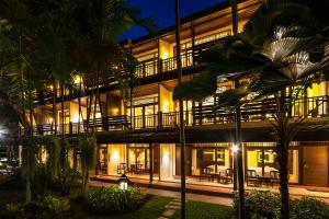 - un bâtiment avec des tables et des chaises en face du complexe dans l'établissement Ratchapruek Lanna Boutique, à Chiang Mai