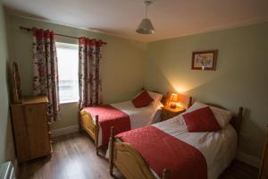 a small bedroom with two beds and a window at Arasáin Bhalor in Falcarragh