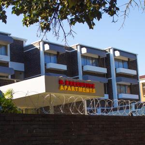 a building with a sign that reads acquiring apartments at R Executive Apartments in Harare
