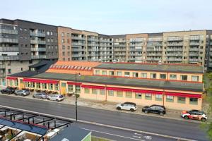 a building with cars parked in a parking lot next to a highway at Foundry Hotel Apartments in Uppsala