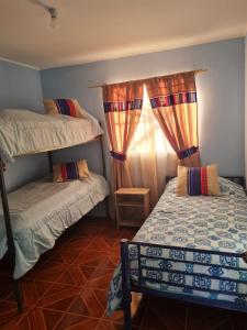 a bedroom with two bunk beds and a window at Cabañas rústico in San Pedro de Atacama