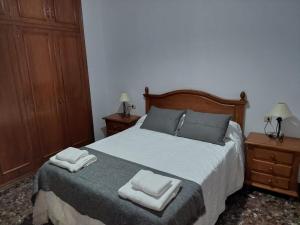 a bedroom with a bed with two towels on it at CASA DOROTEO in Cardeña