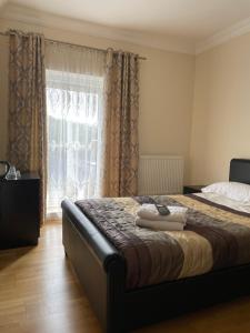 a bedroom with a bed and a window with curtains at The White Lodge Hotel in Hereford