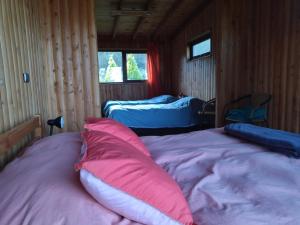 Las Bandurrias Eco Hostal في كوشامو: غرفة نوم بسريرين ومخدة وردية