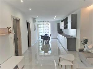 un soggiorno bianco con un tavolo e una cucina di 161 Marinello Apartment a Marsaxlokk