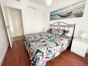 1 dormitorio con 1 cama con un edredón colorido en Apartamento Narváez- Altos Del Tomillar en Torre del Mar