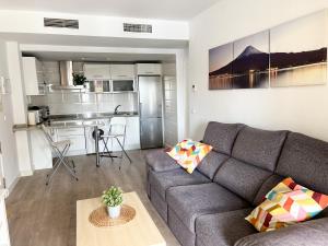 a living room with a couch and a kitchen at Apartamento Narváez- Altos Del Tomillar in Torre del Mar
