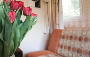 a vase of red tulips sitting next to a couch at Holiday Home Morag Kretowiny V in Pojezierce